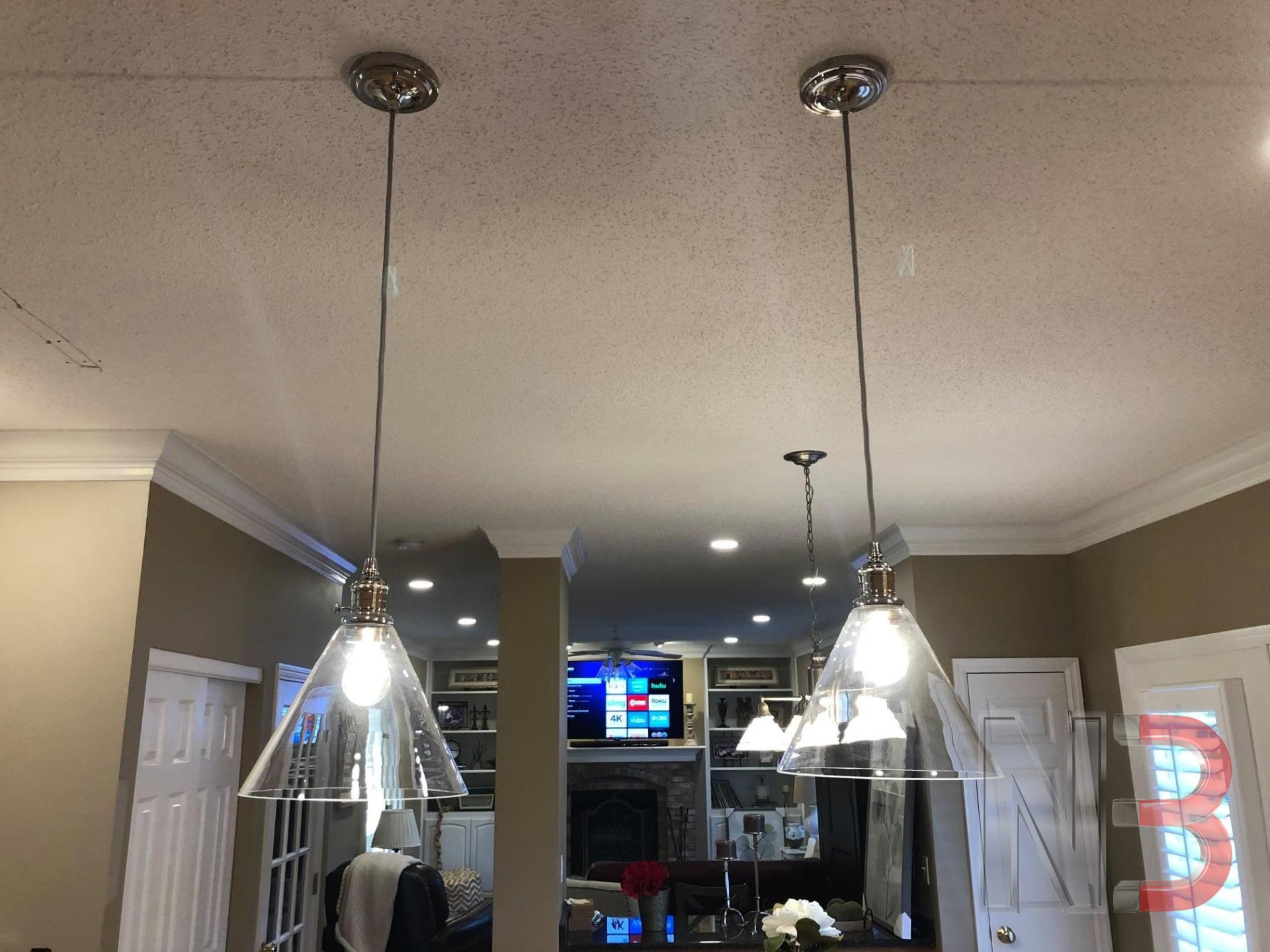 Two glass pendant lights newly hung from the kitchen ceiling