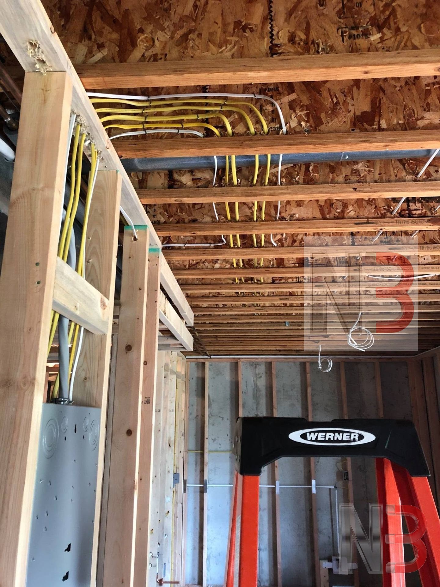Neatly routed circuit wiring running through ceiling joists in a new construction home