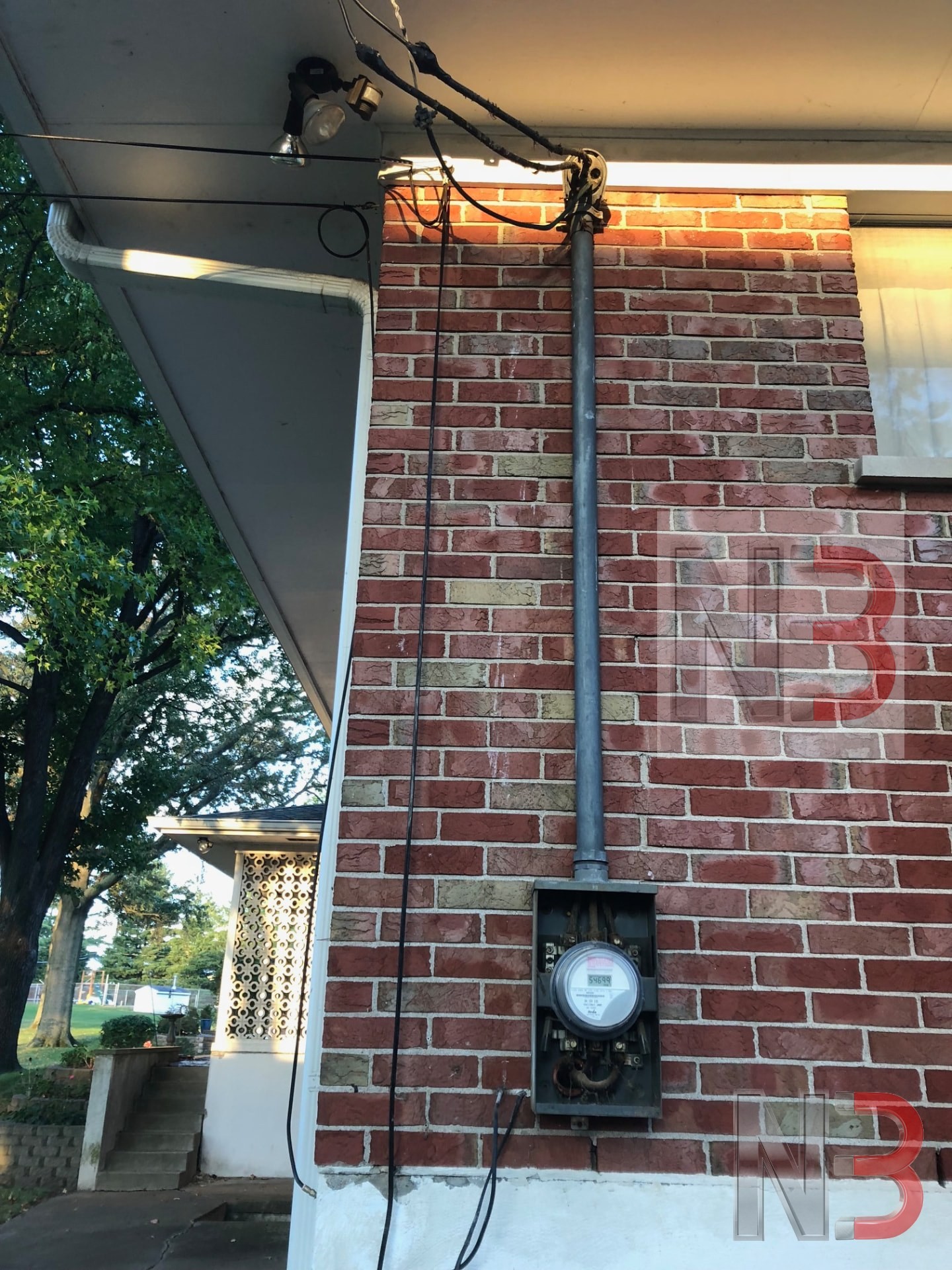 Old weatherhead, meter socket and service riser on a brick home before a service change