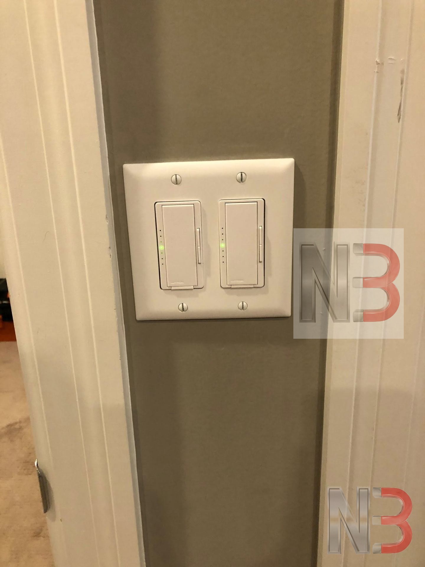 Two new dimmer switches installed in a white double gang wall plate